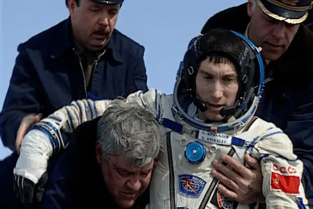 Serghei Krikalev, fostul cosmonaut sovietic, este ajutat să iasă din capsulă după aterizarea pe Pământ, la încheierea misiunii sale prelungite în spațiu
