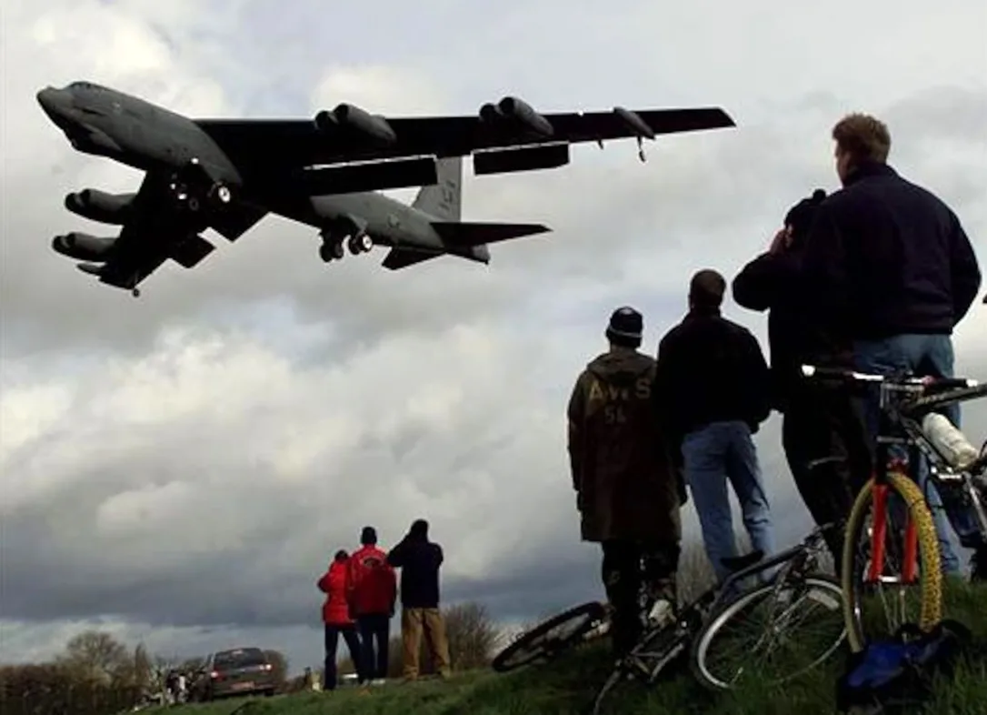 Un bombardier B-52 este privit de un grup de curioși în timp ce aterizează la baza RAF Fairford, din Anglia, pe 21 februarie 1999. Avioanele B-52 au sosit din SUA în cadrul pregătirilor NATO pentru atacuri aeriene asupra Iugoslaviei, pe fondul intensificării tensiunilor legate de criza din Kosovo.