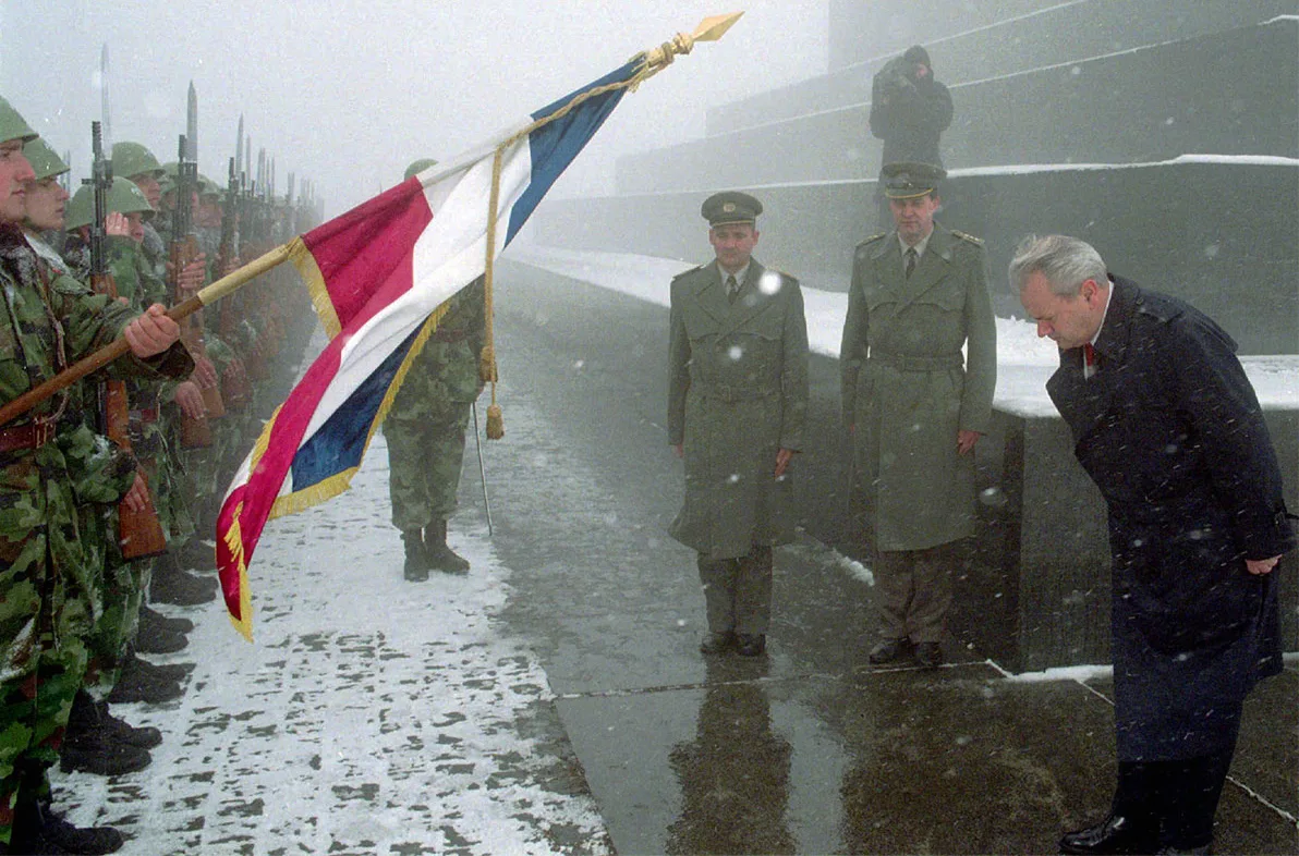 Președintele sârb Slobodan Milošević se înclină în fața drapelului sârb în timpul unei ceremonii la Monumentul Soldatului Necunoscut din Belgrad, în 1996